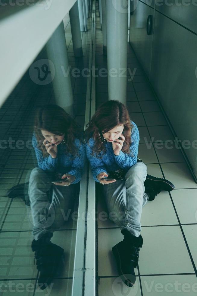 junge Frau allein und müde in einem Busbahnhof foto