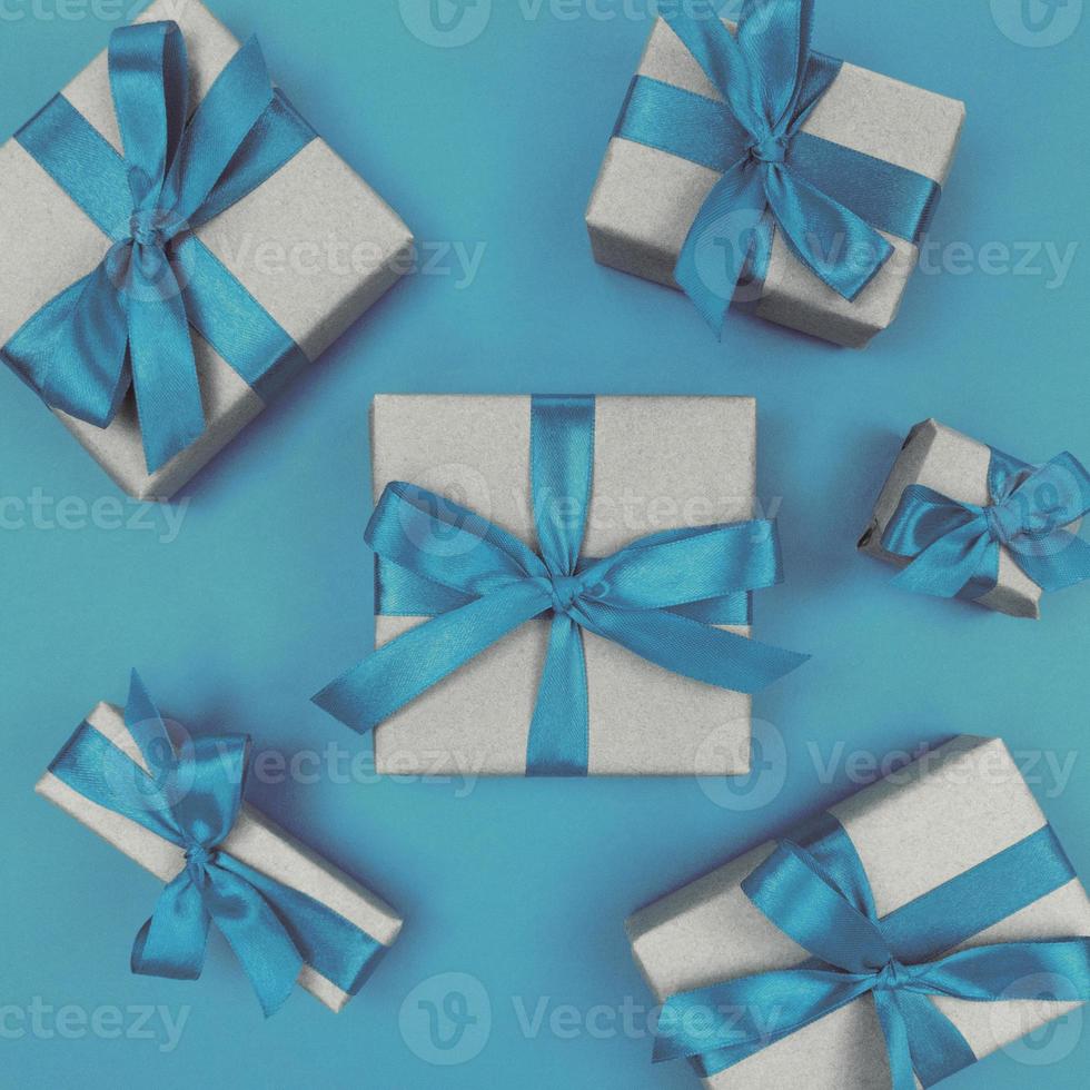 Geschenkboxen in Kraftpapier mit blauen Bändern und Schleifen verpackt. festliche monochrome flache Lage. foto