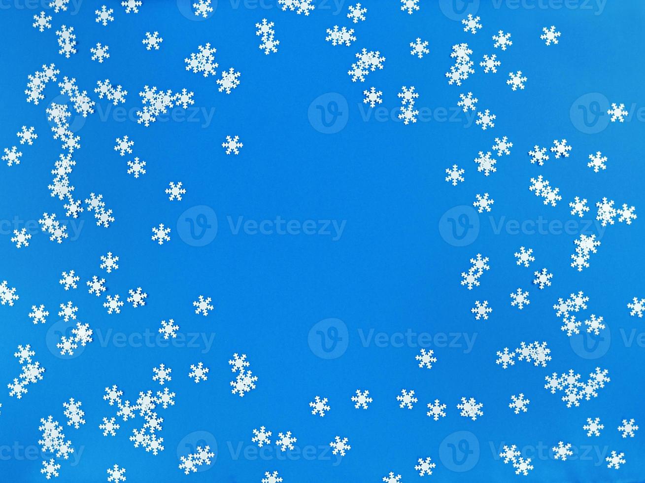 verstreute weiße Schneeflocken auf blauem Grund. einfache flache Lage mit Kopienraum. Stock Foto. foto