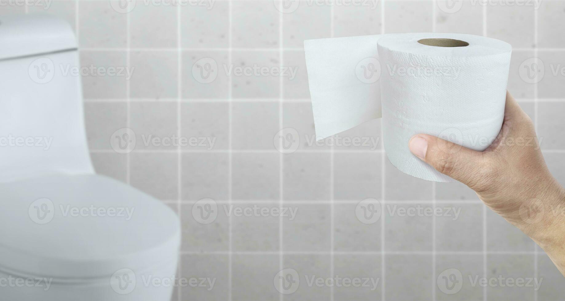 Eine an Durchfall erkrankte Person hält eine Rolle Toilettenpapier vor die Toilettenschüssel foto