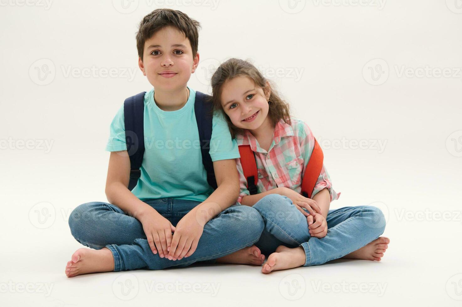 glücklich Schule Kinder mit Rucksäcke, Lächeln suchen beim Kamera, isoliert Über Weiß Studio Hintergrund. zurück zu Schule Konzept foto