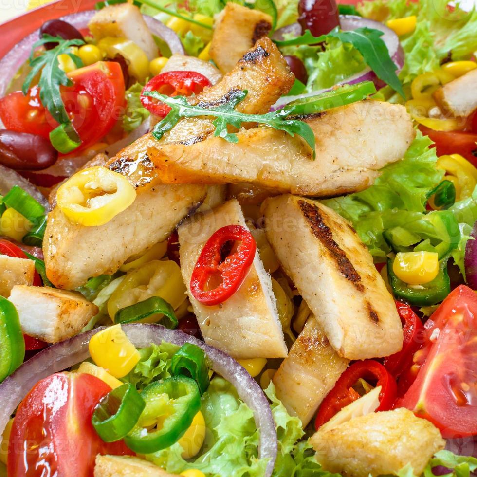 mexikanischer würziger Hühnersalat auf dem Teller. gegrilltes Hühnerfleisch mit leckerer Gemüseauswahl. foto