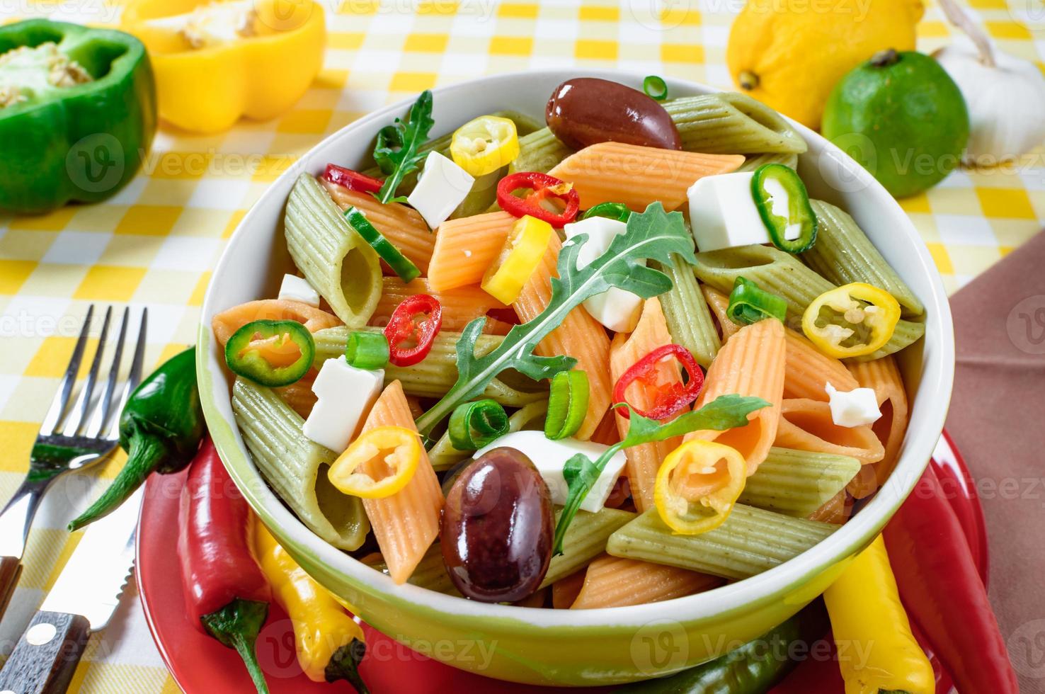 Nudelsalat mit Tomaten, Rucola, Gurken, Paprika, Peperoni, schwarzen und grünen Oliven und Käse-Feta. Ansicht von oben. foto