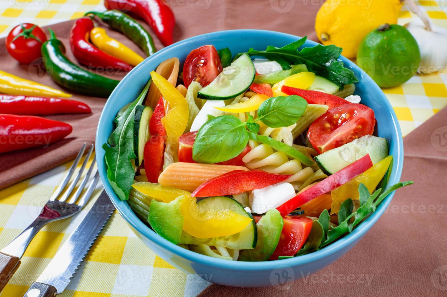 Nudelsalat mit Tomaten, Rucola, Gurken, Paprika, Peperoni, schwarzen und grünen Oliven und Käse-Feta. Ansicht von oben. foto