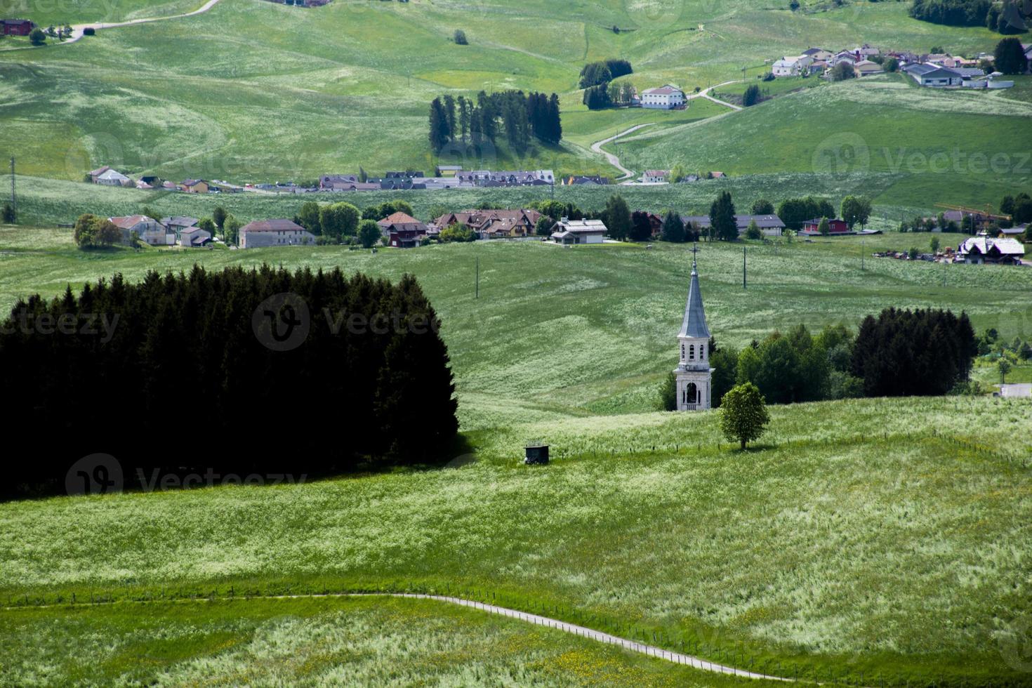 Glockenturm und grüne Weiden foto