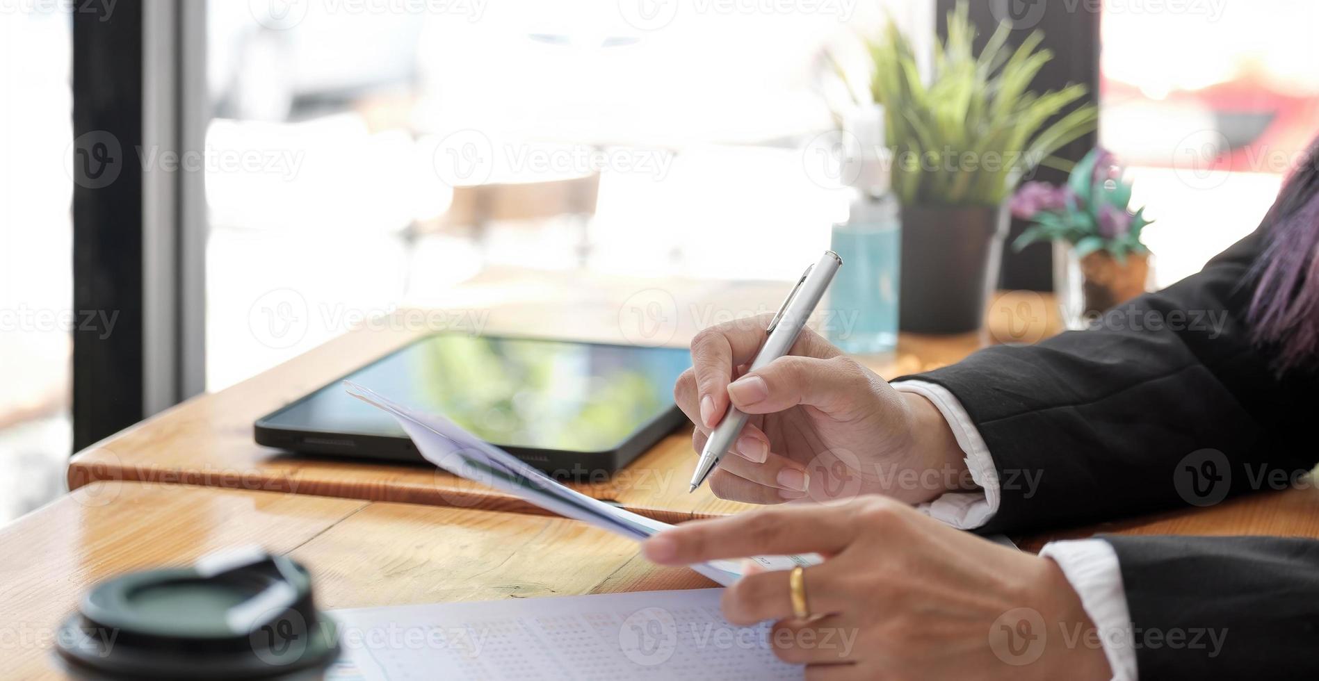 Geschäftsfrau Hände arbeiten mit Finanzen über Kosten und Laptop mit Tablet, Smartphone im Büro im Morgenlicht foto