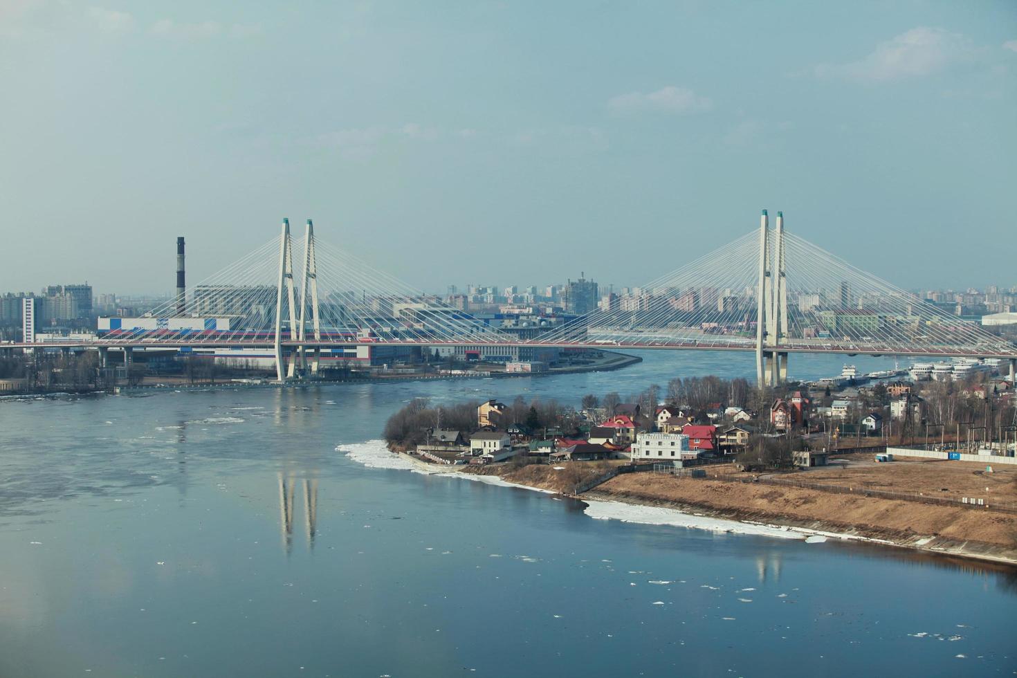 Stadtbild mit Schrägseilbrücke über einen breiten, gewundenen Fluss foto