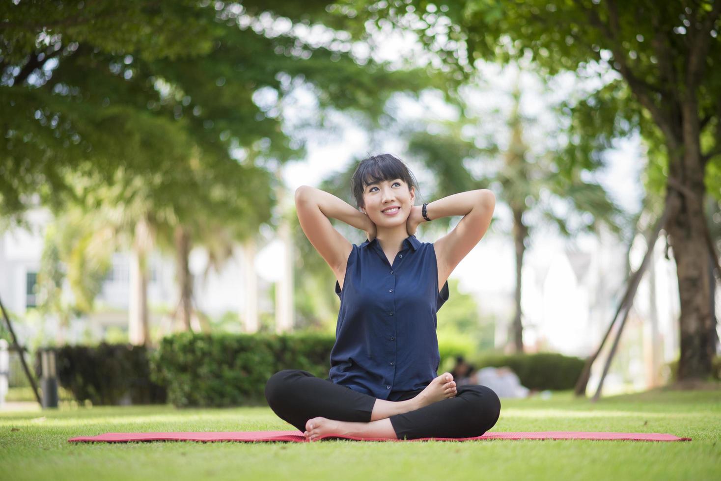 schöne Yoga-Frau auf grünem Park foto