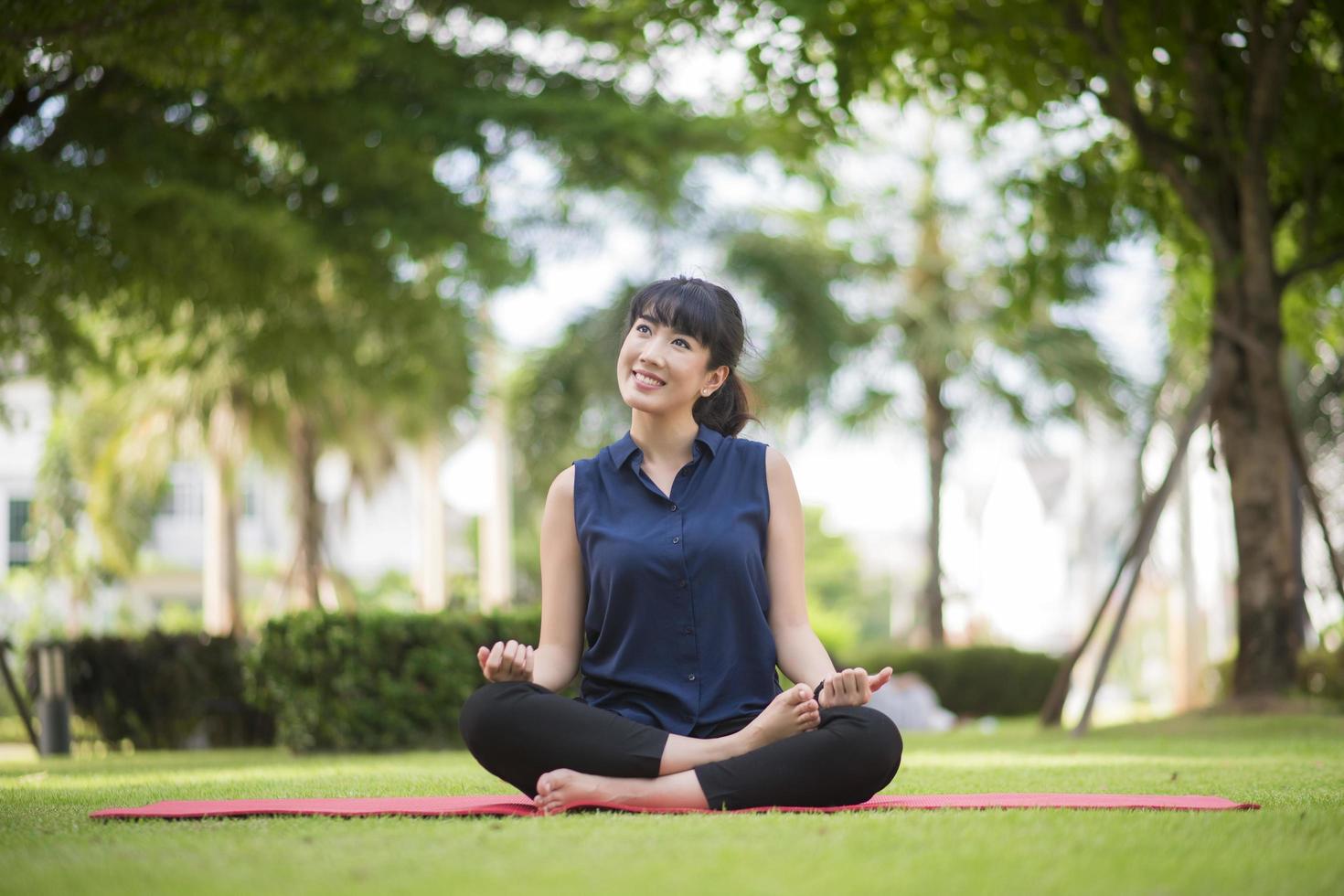 schöne Yoga-Frau auf grünem Park foto