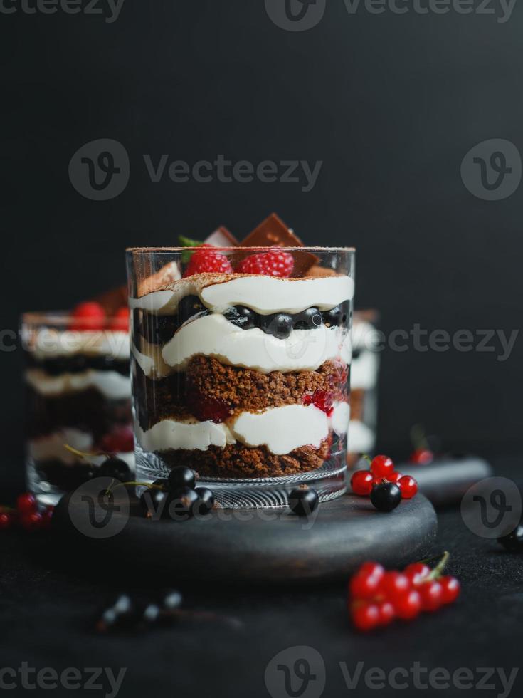 süßes kleines hausgemachtes Kleinigkeitendessert mit Himbeeren, schwarzen Johannisbeeren und Frischkäse. foto