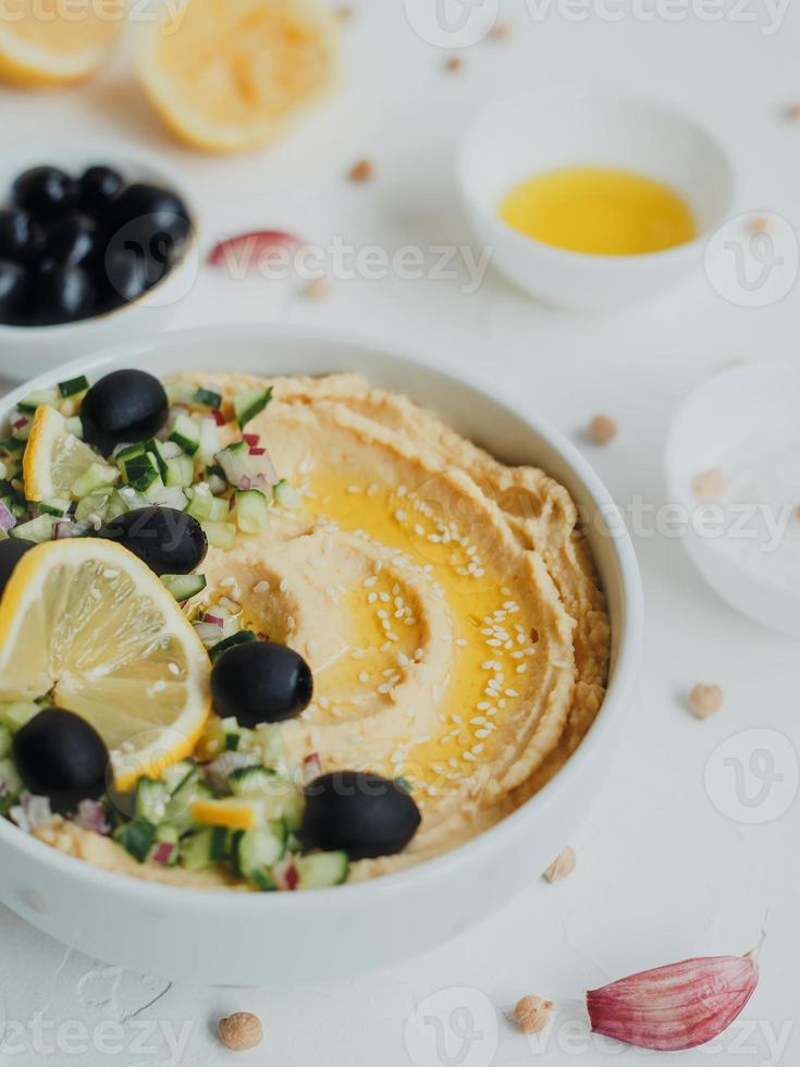 Hummus aus Kichererbsen, mit Olivenöl, Oliven, Zitrone, Knoblauch, Sesam, Zwiebeln und Gurken. foto