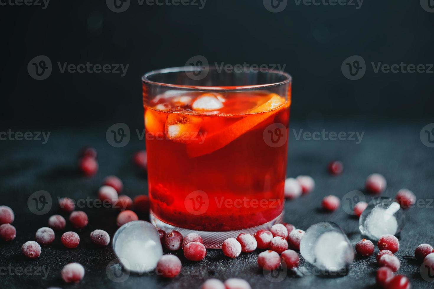 Aperol Spritz mit Eis und Preiselbeeren auf schwarzem Hintergrund. foto