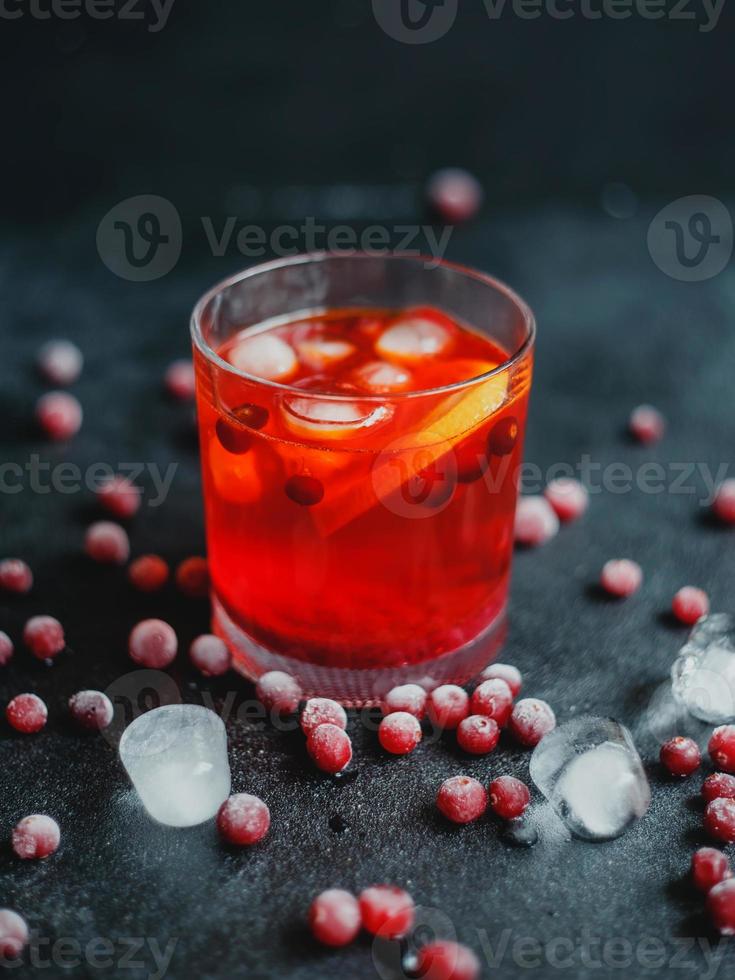 Aperol Spritz mit Eis und Preiselbeeren auf schwarzem Hintergrund. foto