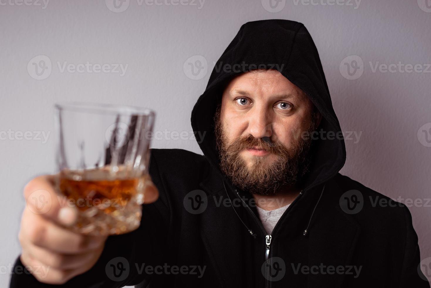 schöner eleganter bärtiger Mann mit schwarzem Mantel mit Kapuze foto