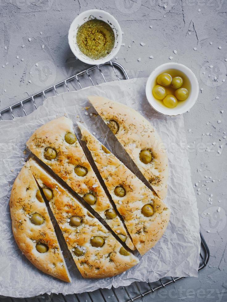 traditionelles italienisches Focaccia-Brot mit Oliven, Rosmarin, Salz und Olivenöl. hausgemachte Focaccia. foto