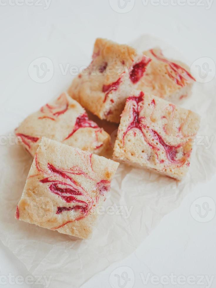 hausgemachte Blondies aus weißer Schokolade mit frischen Himbeeren auf hellem Hintergrund. foto