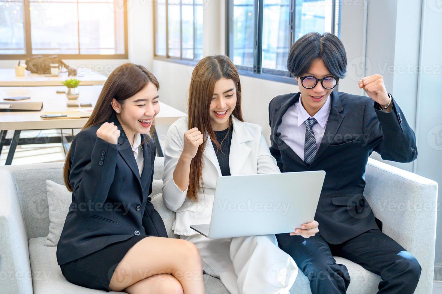 eine Gruppe von 3 Geschäftsleuten freut sich vor dem Computer. foto