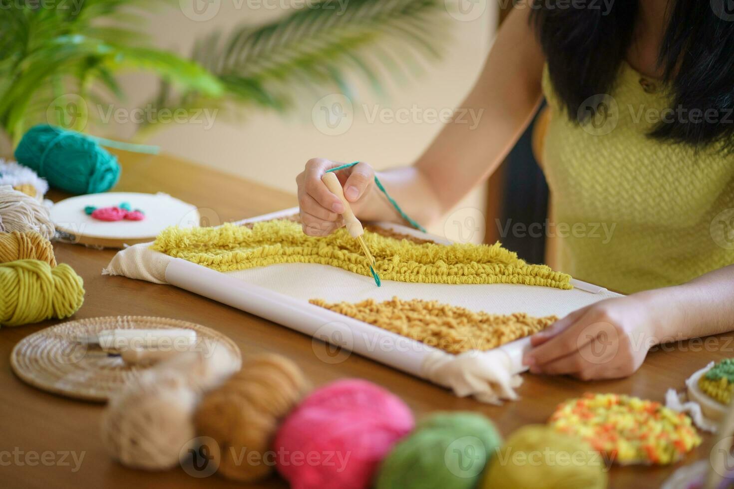 schlagen Nadel. asiatisch Frau Herstellung handgemacht Hobby Stricken im Studio Werkstatt. Designer Arbeitsplatz handgemacht Kunst Projekt DIY Stickerei Konzept. foto