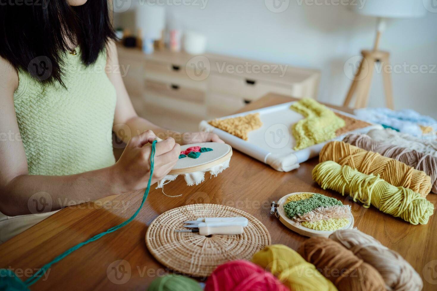 schlagen Nadel. asiatisch Frau Herstellung handgemacht Hobby Stricken im Studio Werkstatt. Designer Arbeitsplatz handgemacht Kunst Projekt DIY Stickerei Konzept. foto