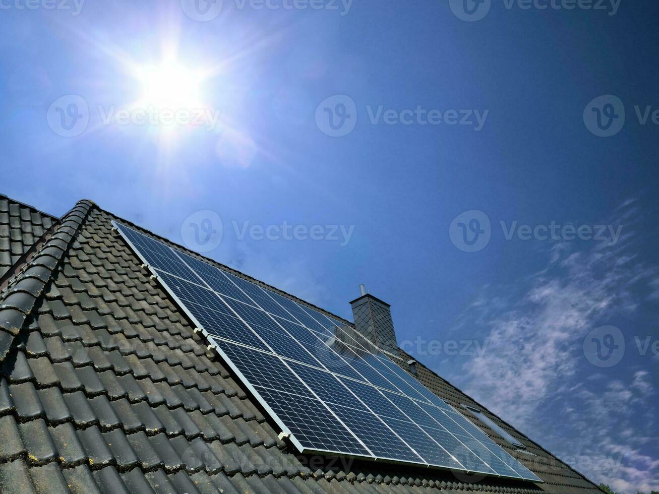 Sonnenkollektoren produzieren saubere Energie auf dem Dach eines Wohnhauses foto