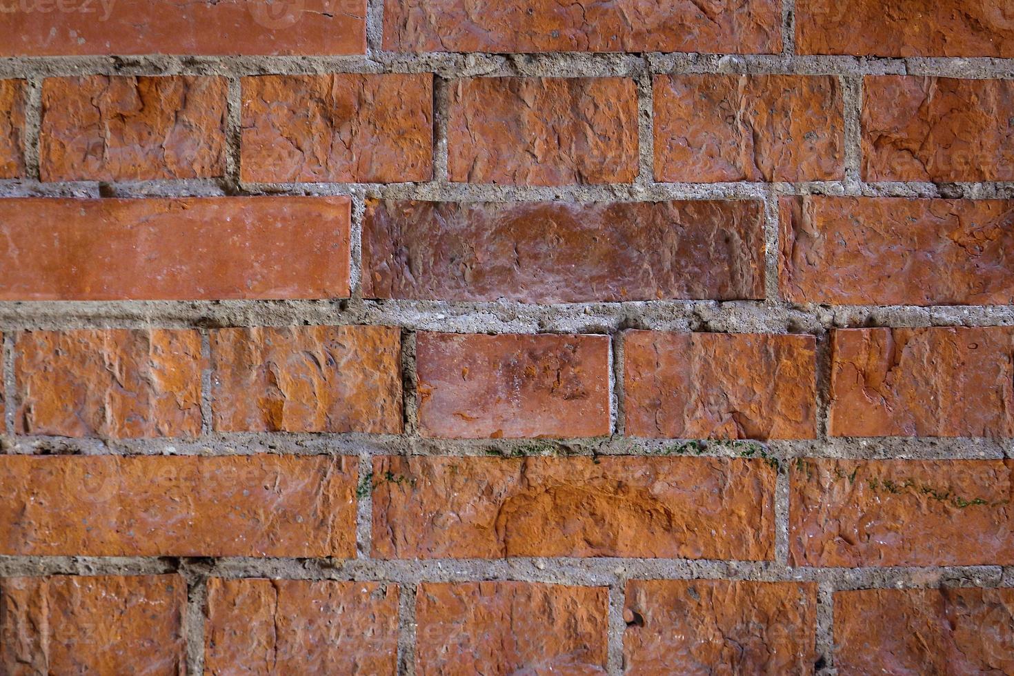 rote Backsteinmauer mit hellen Nähten und unebener Oberfläche foto