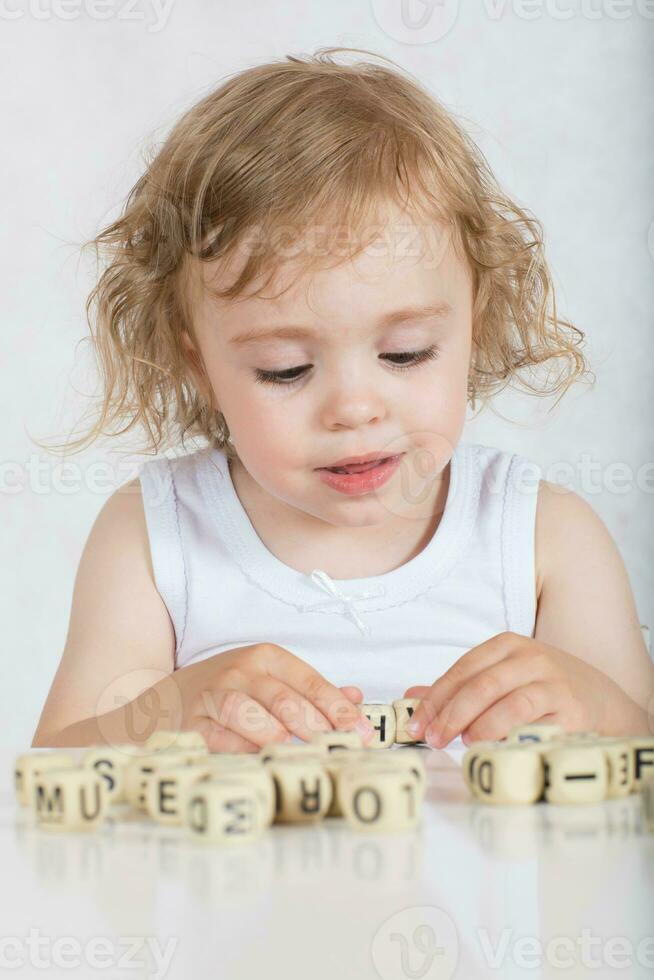 klein Mädchen komponiert Wörter von Briefe. Nahansicht foto