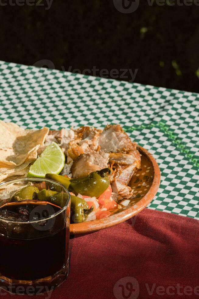 das Mexikaner Carnitas, ein köstlich Essen, ist serviert mit verschiedene Gewürze auf ein Tabelle mit Geschirr foto