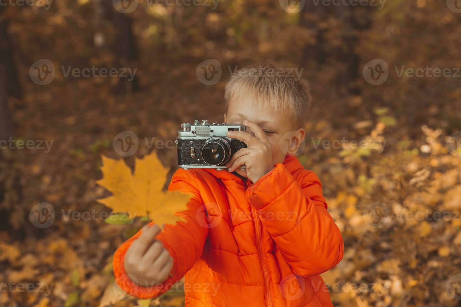 Junge mit retro Kamera nehmen Bilder draussen im Herbst Natur. Freizeit und Fotografen Konzept foto