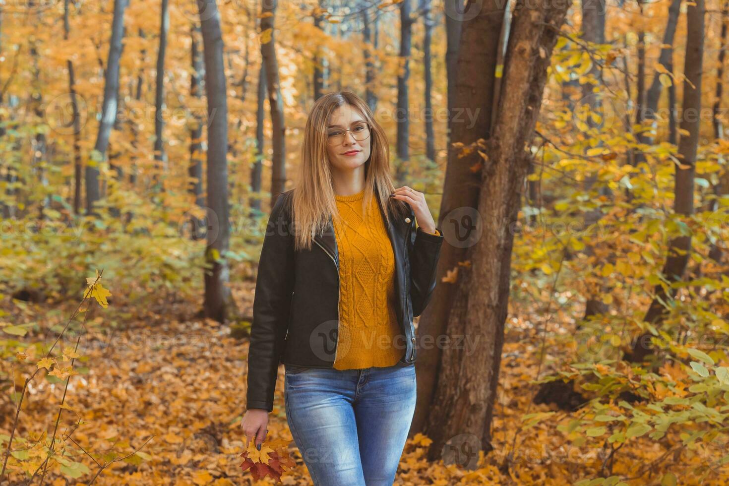 süß Smiley Frau halten Herbst Blätter im fallen Park. saisonal, Lebensstil und Freizeit Konzept. foto