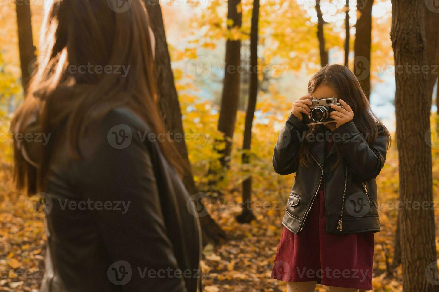 Kind Mädchen Fotograf nimmt Bilder von ein Mutter im das Park im Herbst. Hobbys, Foto Kunst und Freizeit Konzept.