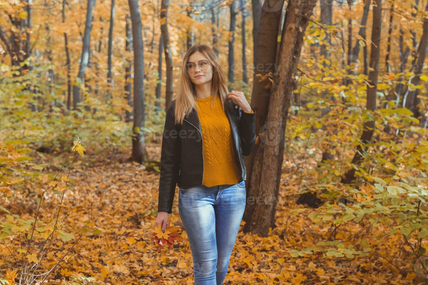 Mädchen hält gefallen Blätter und Spaziergänge im Herbst Park. saisonal Konzept. foto