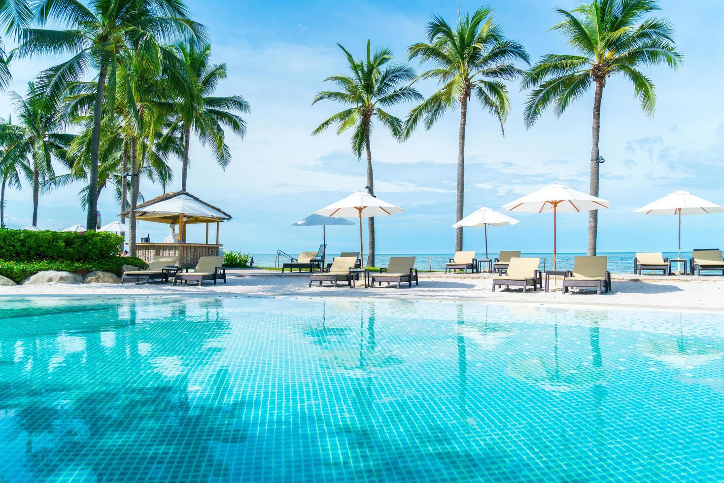 schöner tropischer Strand und Meer mit Sonnenschirm und Stuhl um den Pool im Hotelresort? foto