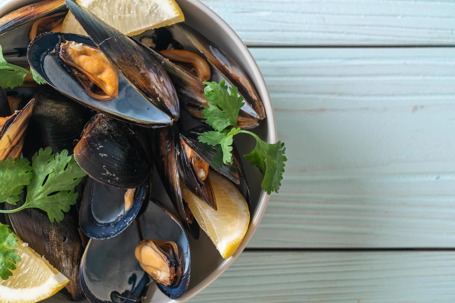 Muscheln mit Kräutern in einer Schüssel mit Zitrone foto