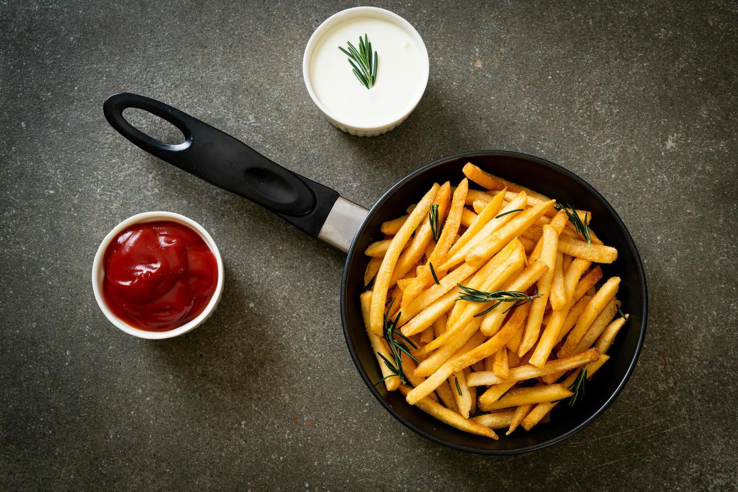 Pommes Frites mit Sauerrahm und Ketchup foto