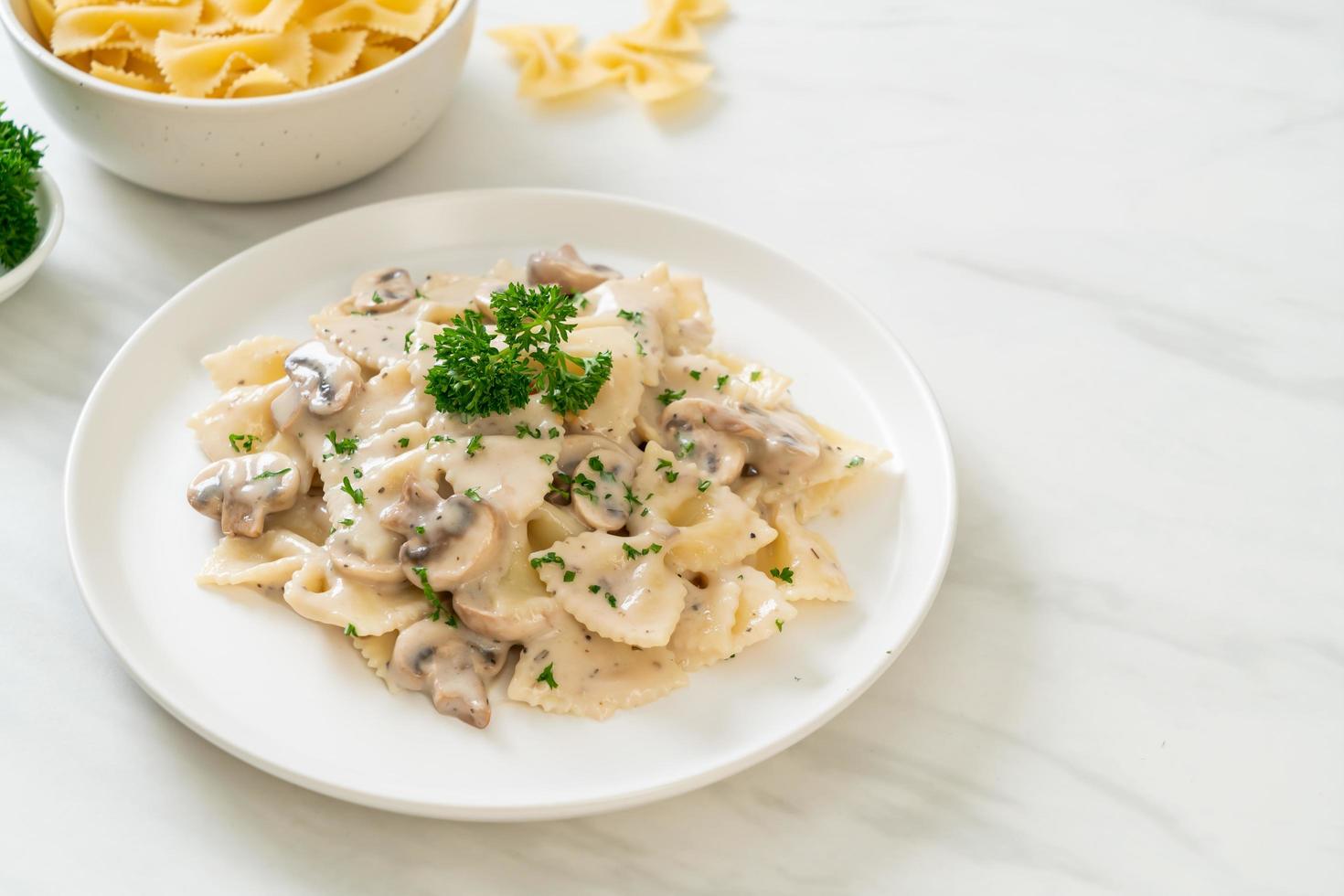 Farfalle-Nudeln mit Champignon-Weiß-Sahne-Sauce - italienische Küche foto