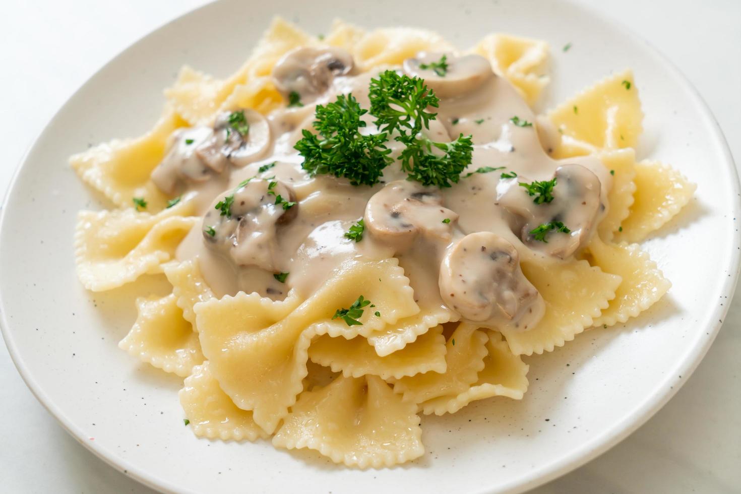 Farfalle-Nudeln mit Champignon-Weiß-Sahne-Sauce - italienische Küche foto