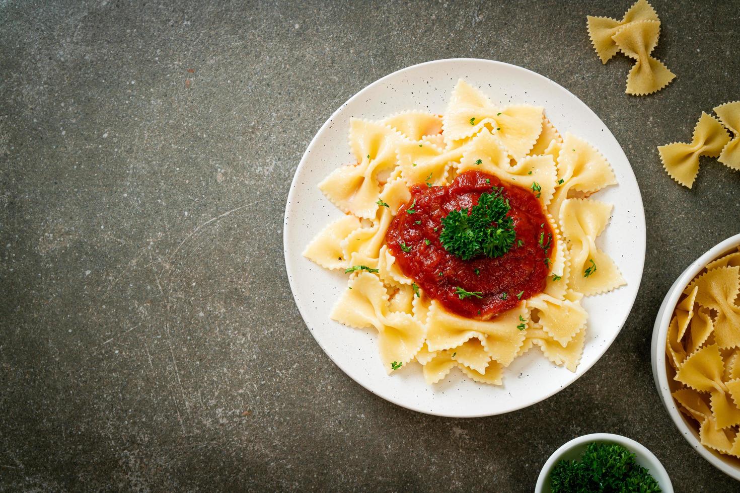 Farfalle-Nudeln in Tomatensauce mit Petersilie - italienische Küche foto