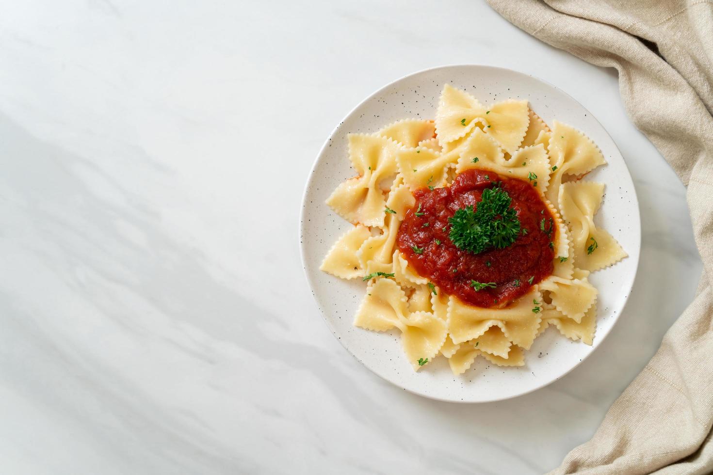 Farfalle-Nudeln in Tomatensauce mit Petersilie - italienische Küche foto