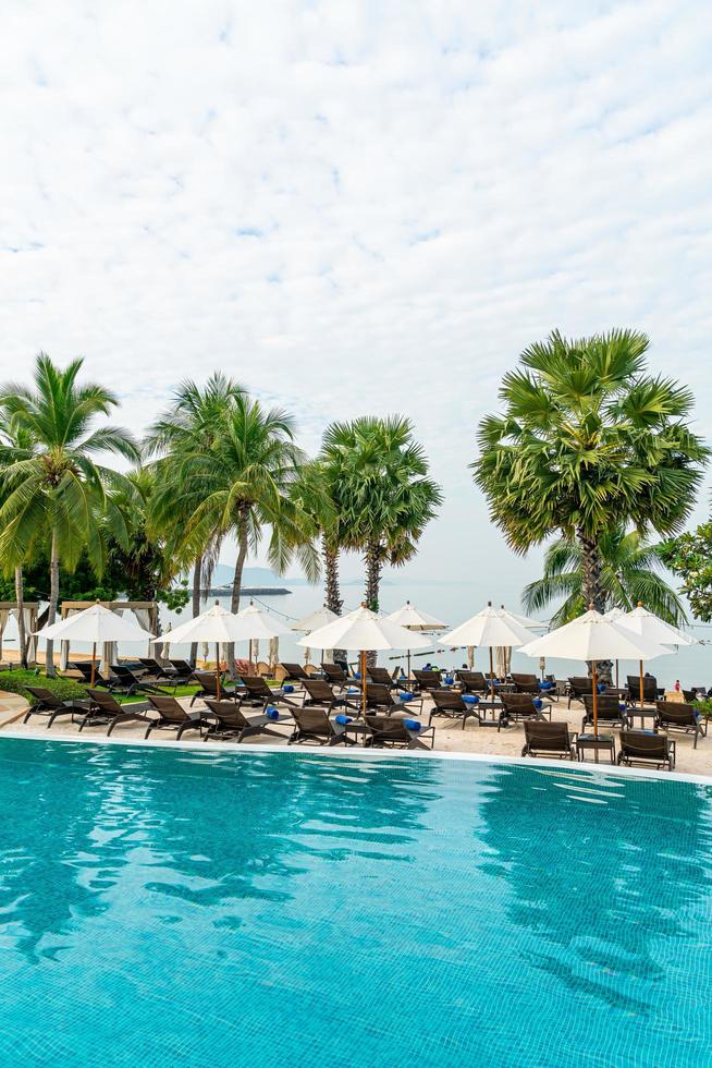 leerer Strandkorb mit Sonnenschirm um den Pool herum foto