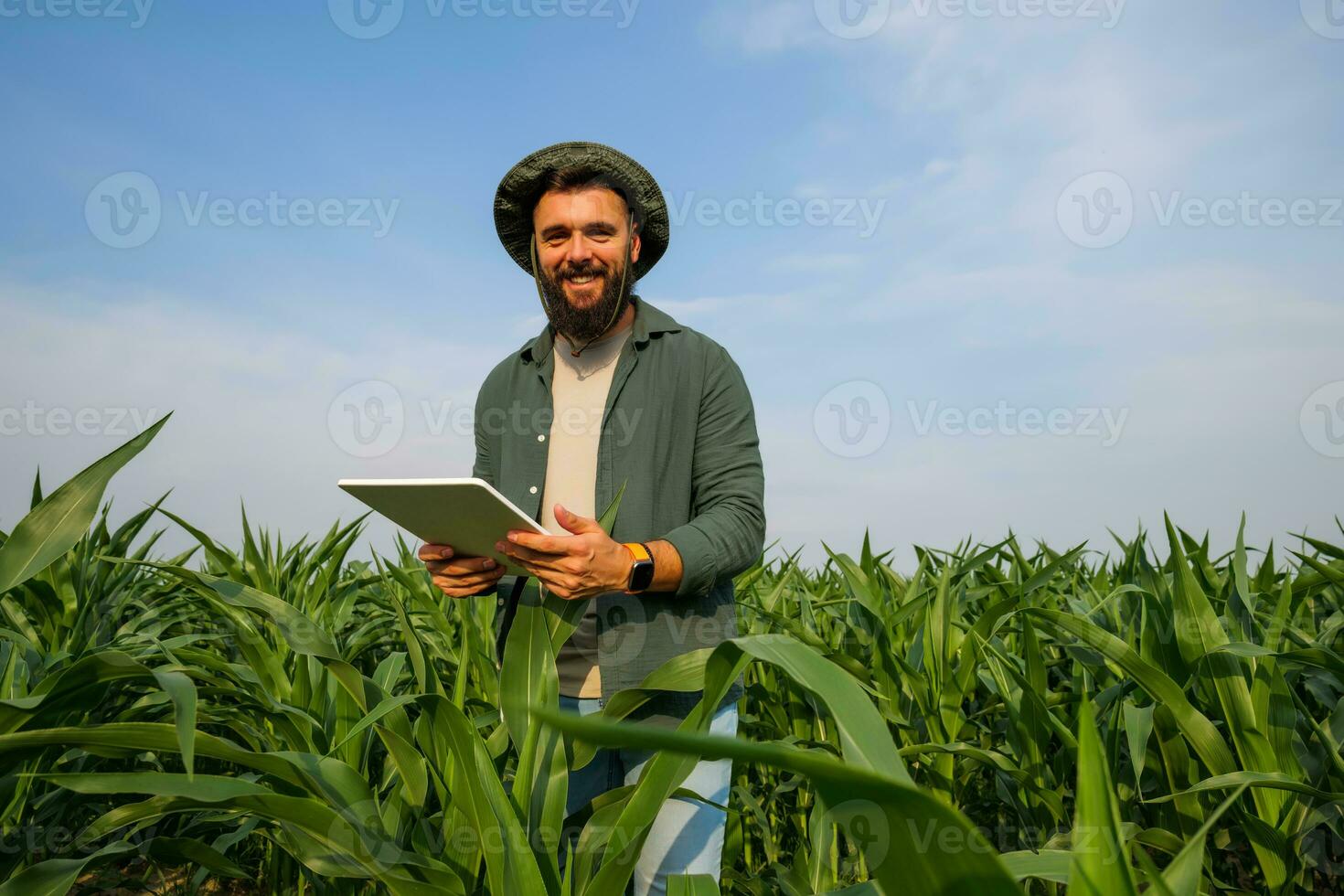 Porträt von Farmer Wer ist kultivieren Mais. sie ist Prüfung Fortschritt von Pflanzen. landwirtschaftlich Beruf. foto