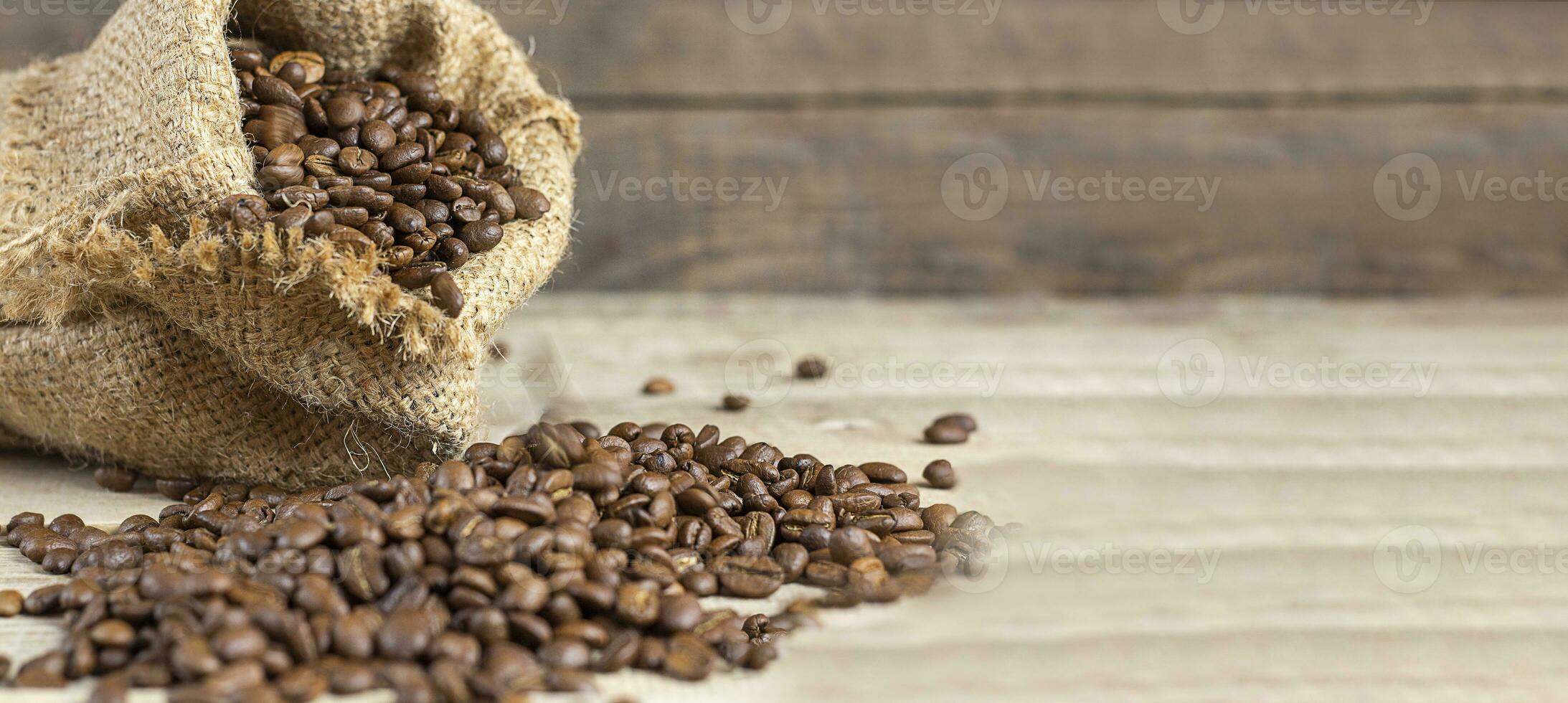 frisch Kaffee Bohnen im Taschen auf ein hölzern Hintergrund. Kopieren Raum. Banner foto