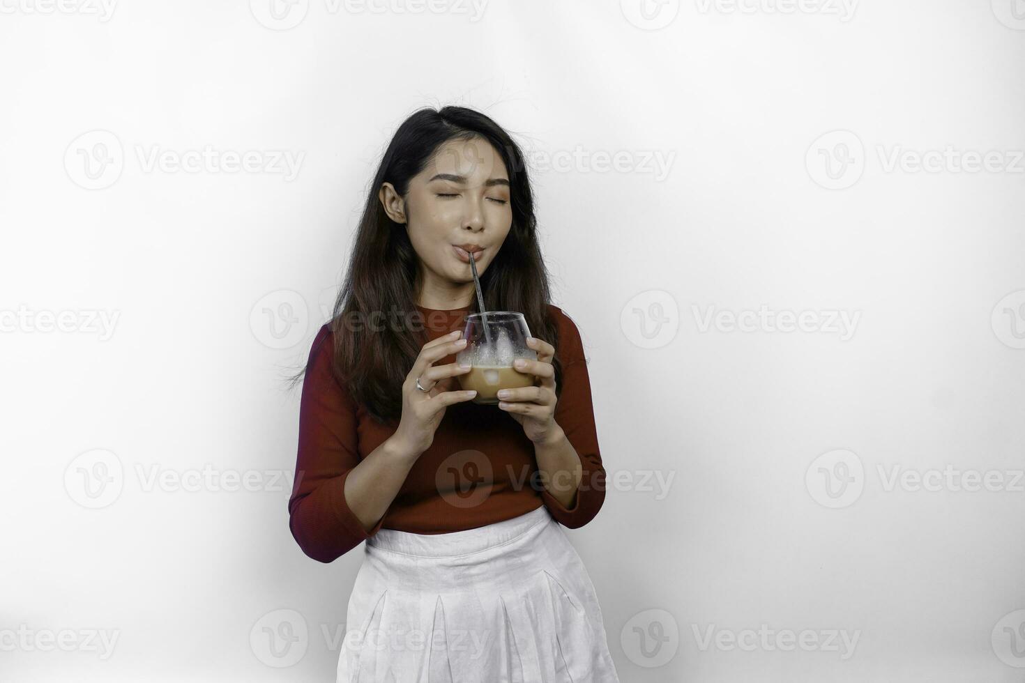 ein asiatisch Mädchen tragen ein rot T-Shirt ist genießen und Trinken ihr Kaffee, isoliert auf Weiß Hintergrund foto