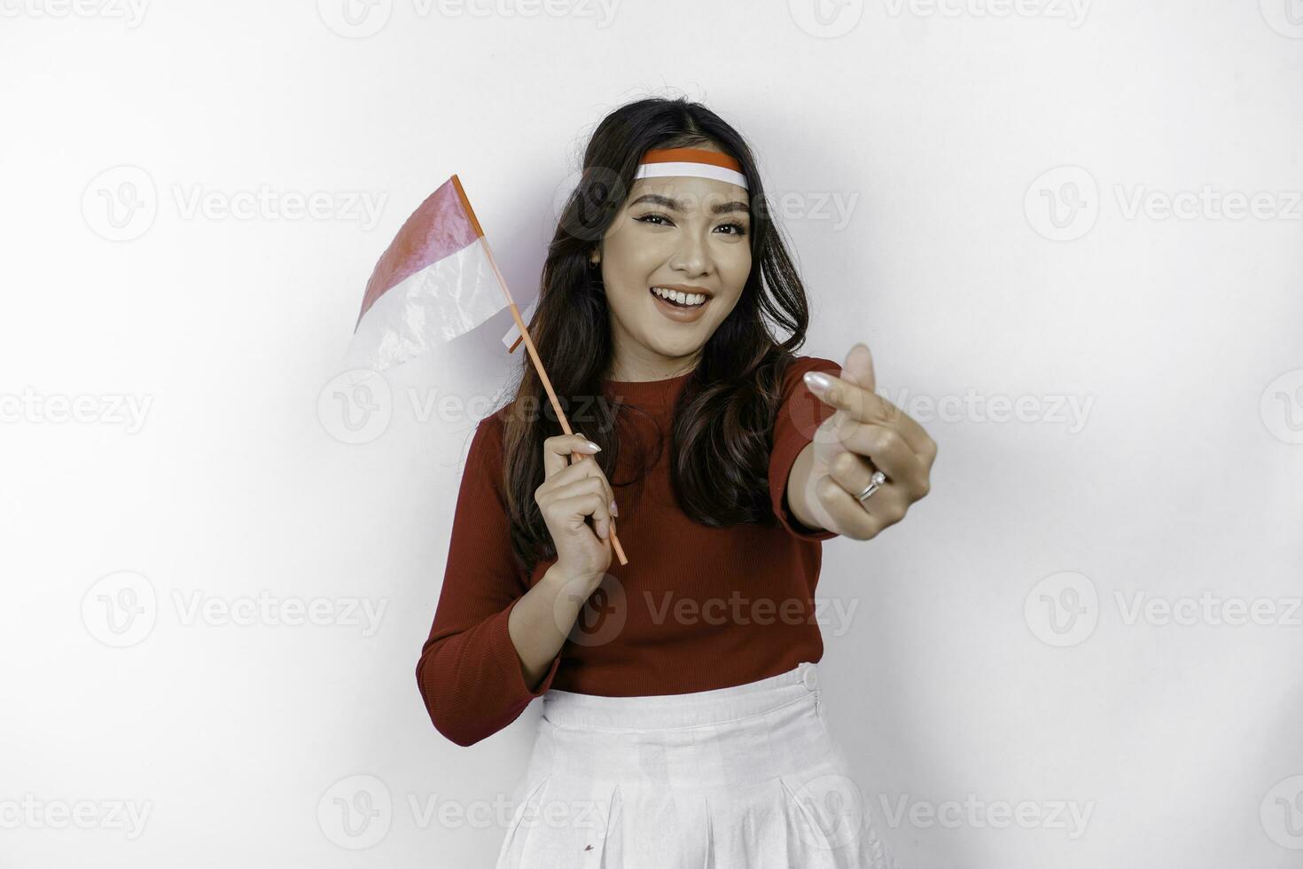 glücklich lächelnd indonesisch Frau halten Indonesiens Flagge und zeigen Liebe Zeichen zu feiern Indonesien Unabhängigkeit Tag isoliert Über Weiß Hintergrund. foto