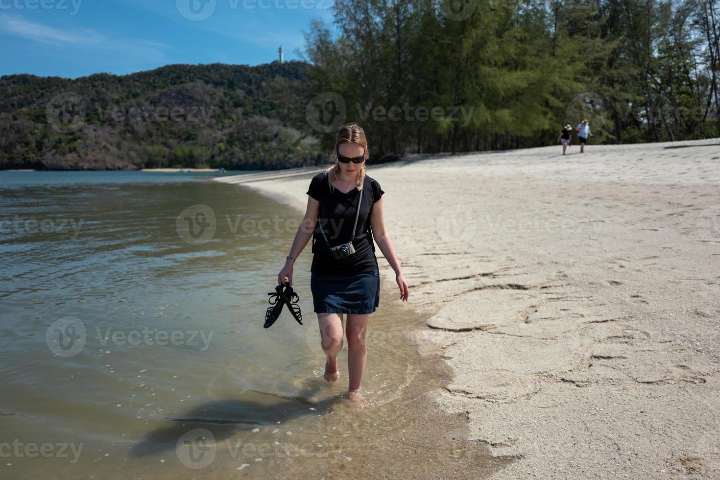 blonde kaukasische Mädchen zu Fuß an einem Strand im Kelim Karst Geoforest Park in Langkawi in Malaysia? foto