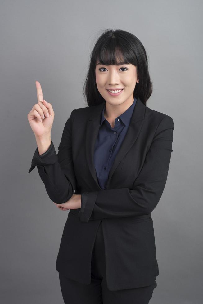 lächelnde Geschäftsfrau im Blazer auf grauem Hintergrund foto