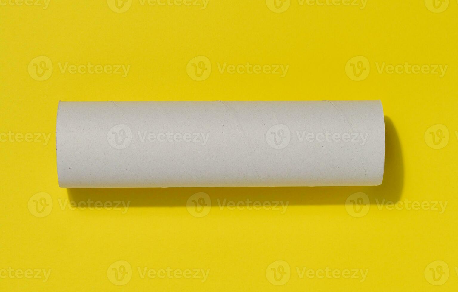 Weiß Papier Handtuch von ein rollen von Küche Handtücher, Objekt auf ein Gelb Hintergrund, oben Aussicht foto