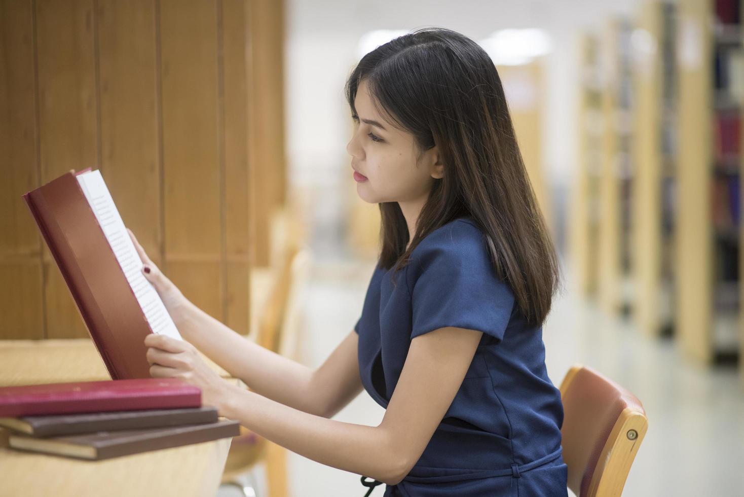 schöne frauen asiatische universitätsstudentin in der bibliothek foto