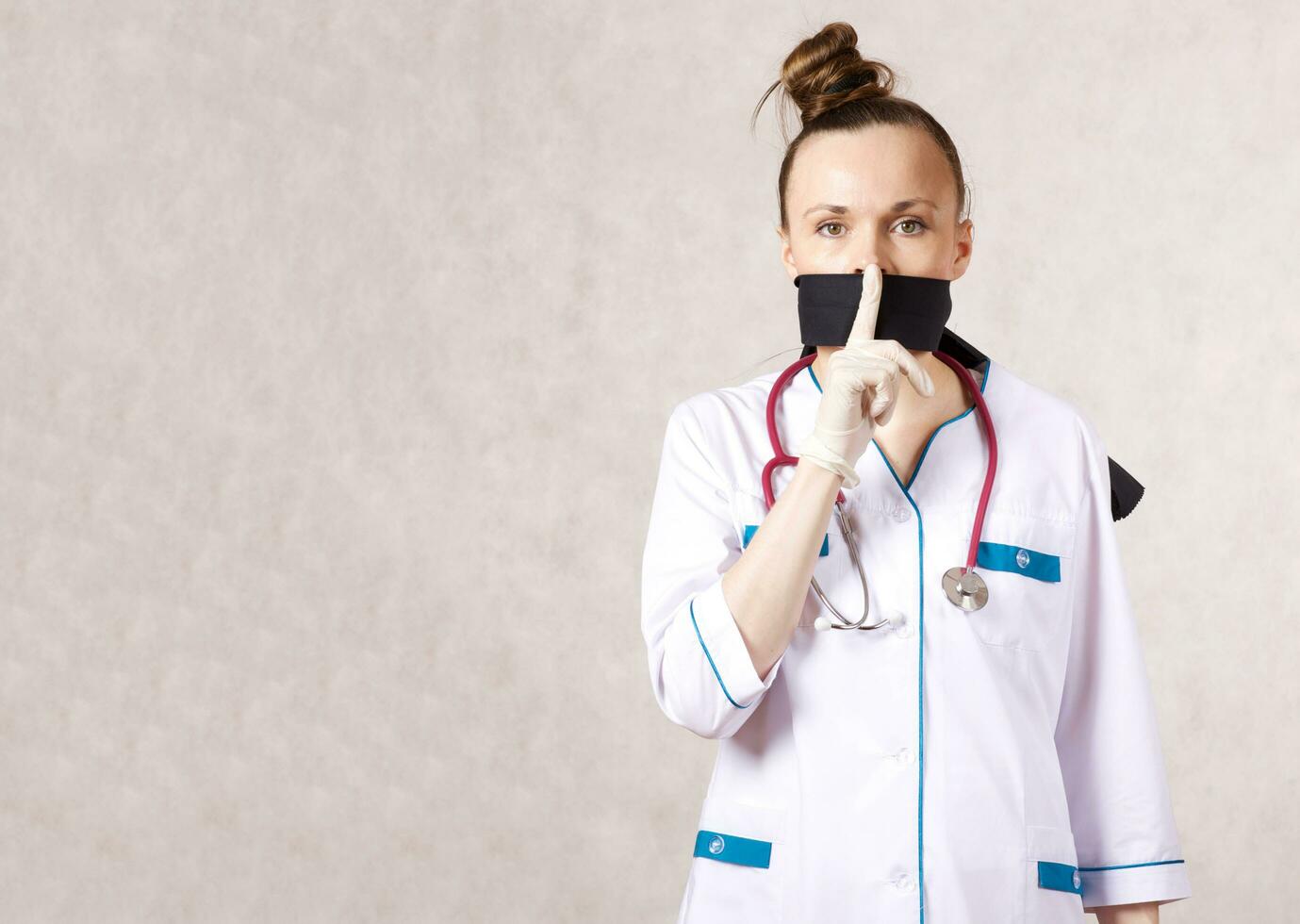 ein jung Frau gekleidet im ein medizinisch Uniform mit ein geschlossen Mund foto