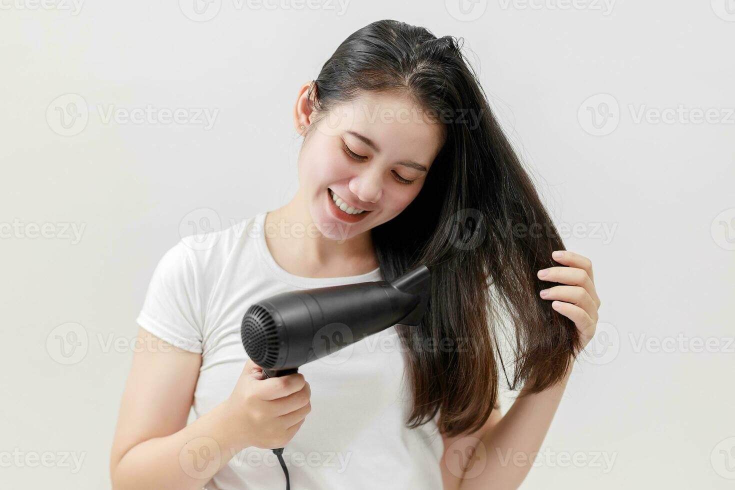 glücklich asiatisch jung Frau Trocknen Haar auf Weiß Hintergrund, Behandlung Haar Konzept, beschädigt Haar, Schönheit Salon. foto