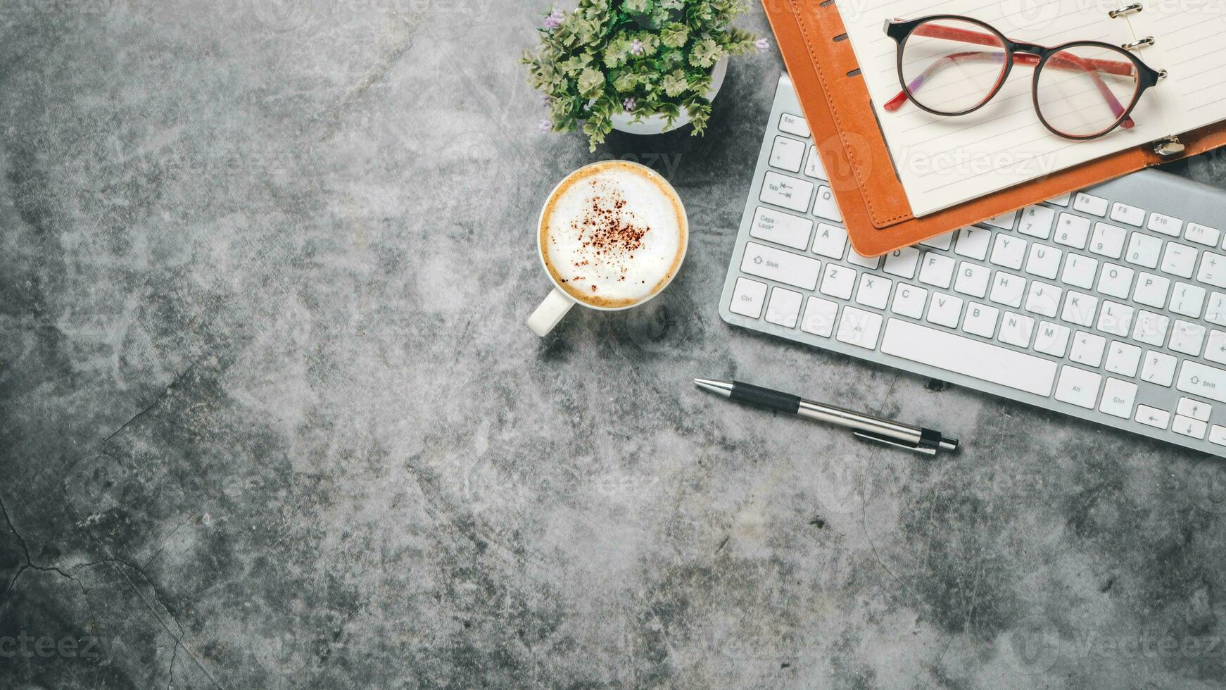 oben Sicht, dunkel Büro Schreibtisch mit Tastatur Computer, Tasse von Kaffee, Stift, Brille und Notizbuch, Kopieren Raum, spotten hoch.. foto